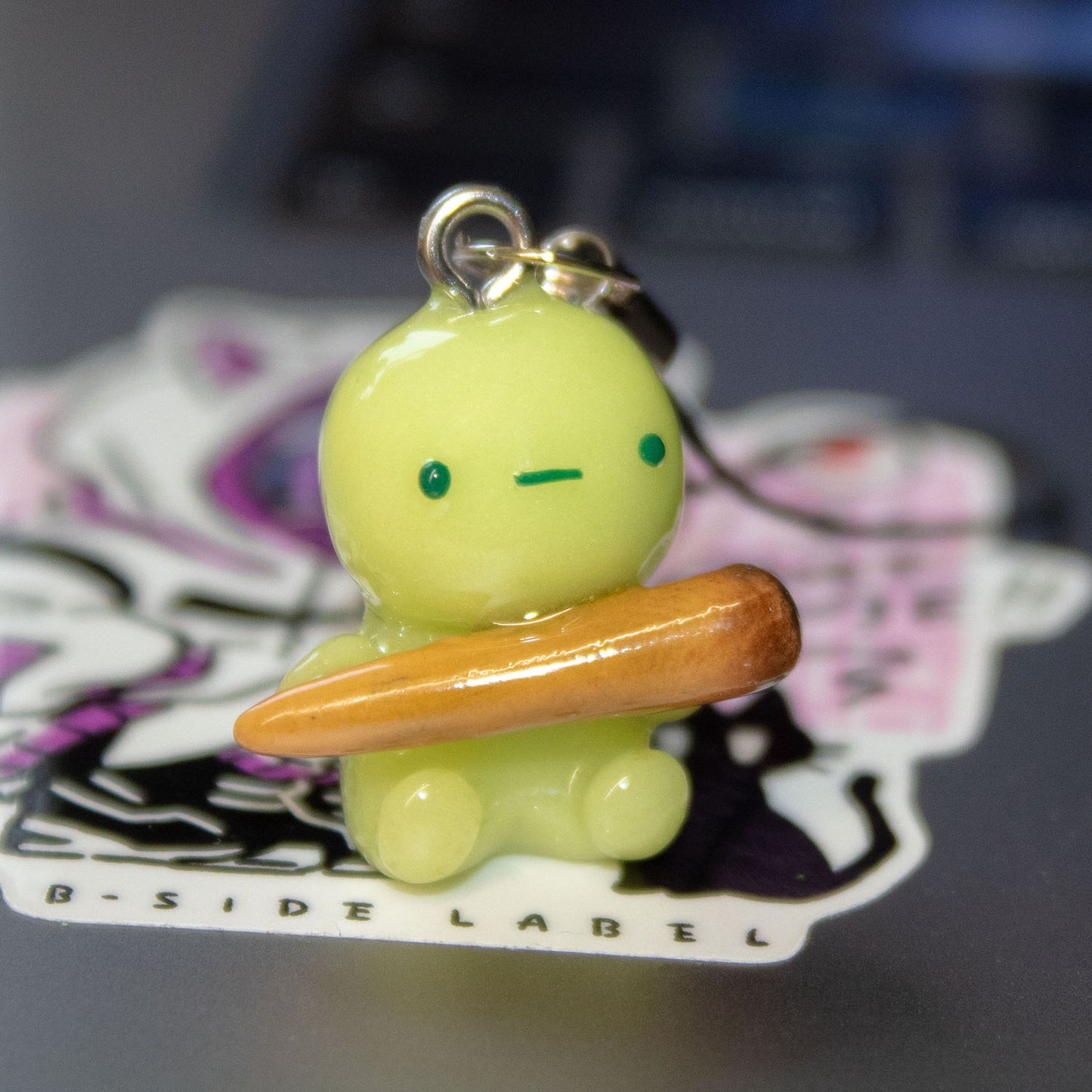 green guy with funny stick phone charm/keychain